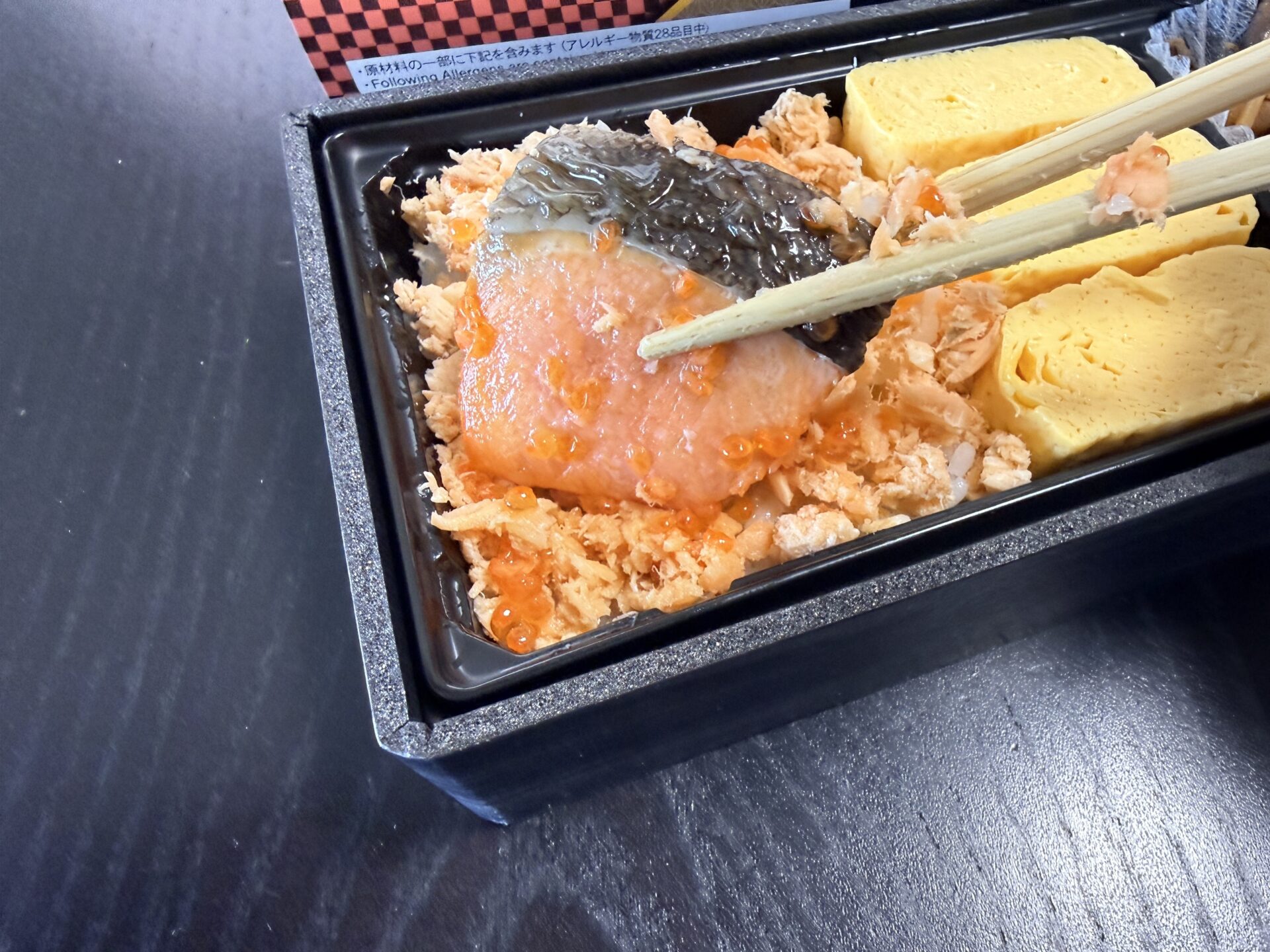 だし巻玉子と鮭はらこ飯の実食シーン。箸で鮭の切身を持ち上げると、下のいくらと鮭ほぐしが見える