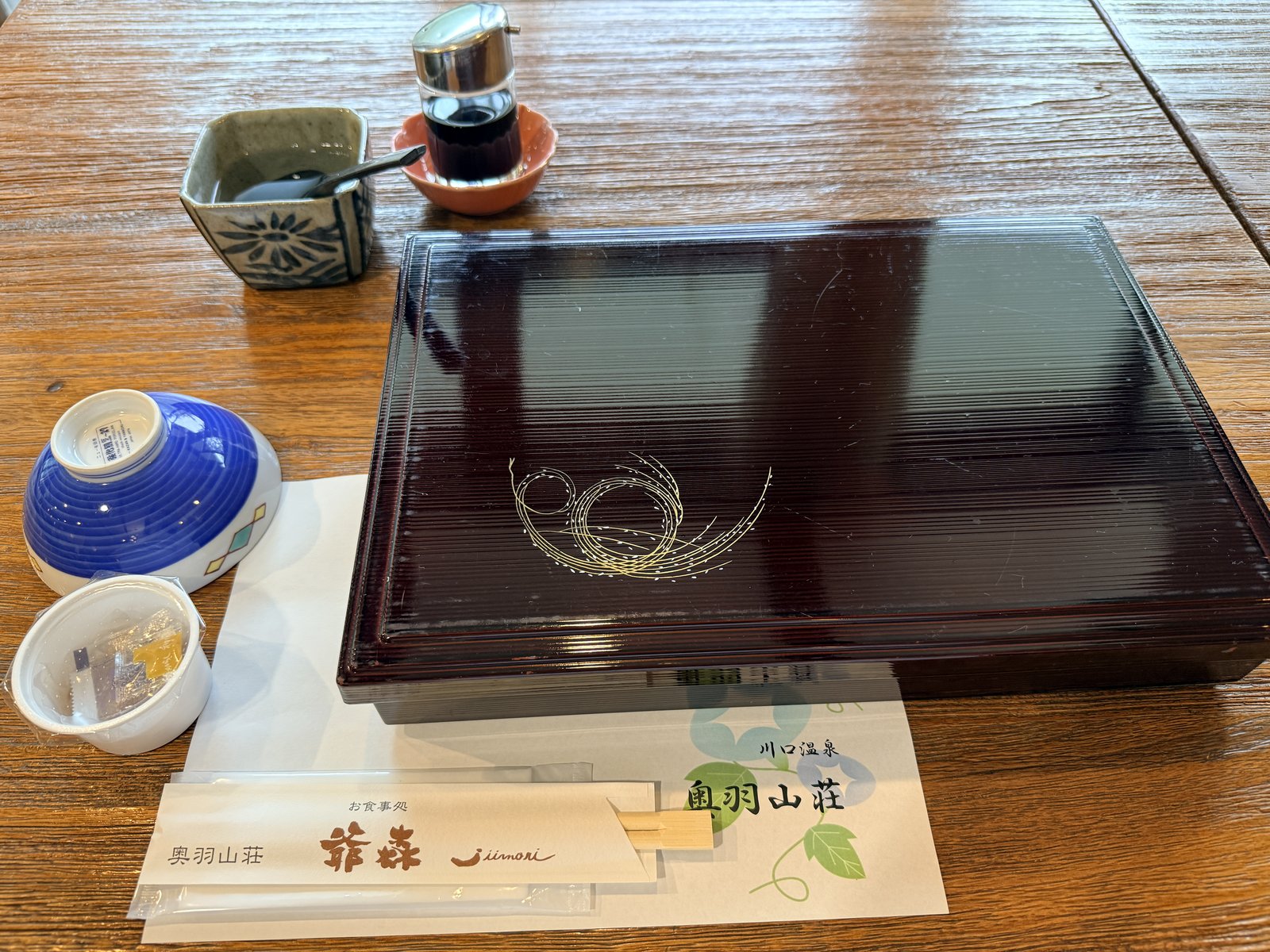 川口温泉 奥羽山荘の朝食膳とロゴ入り敷紙