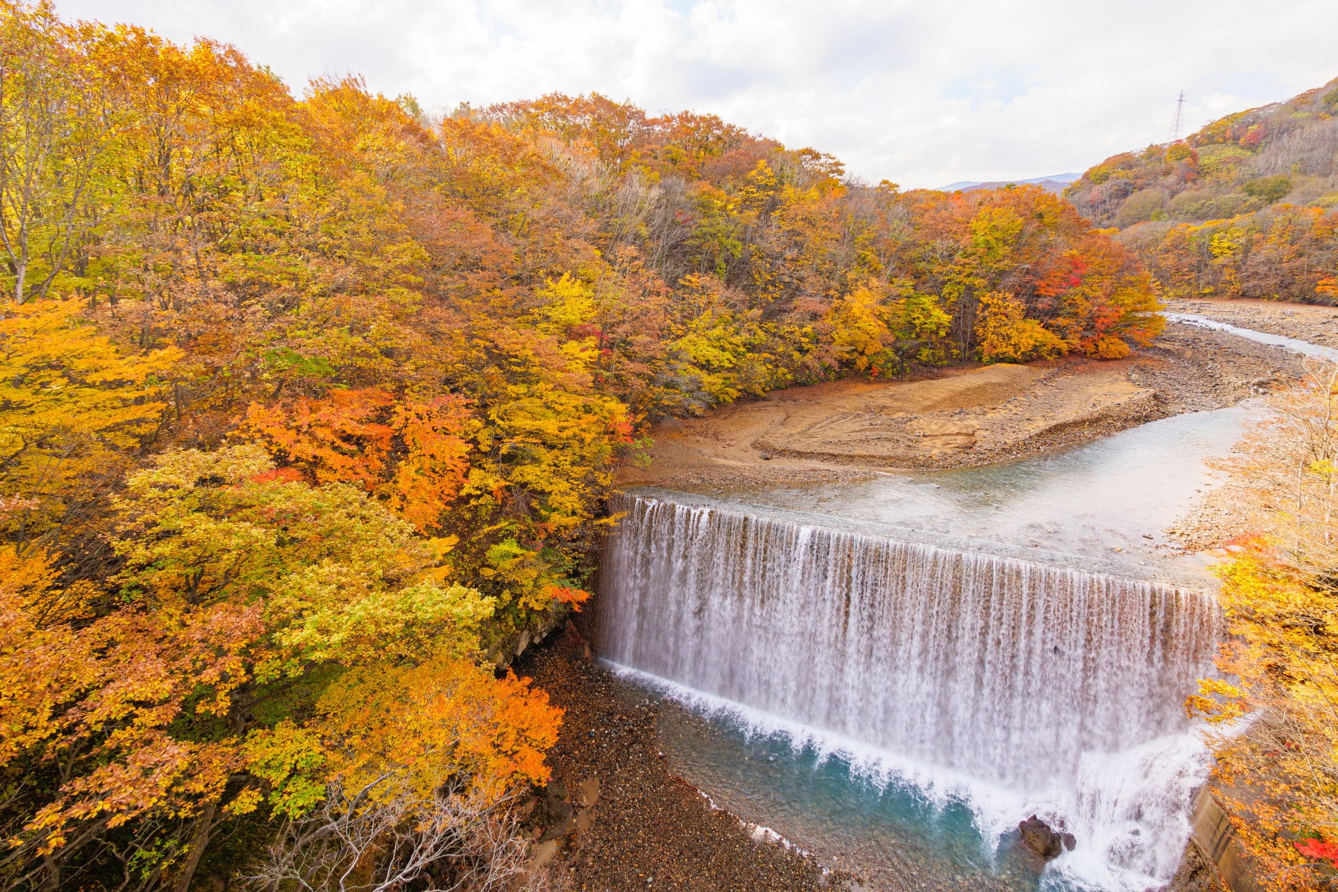 紅葉に包まれた渓谷と流れ落ちる水