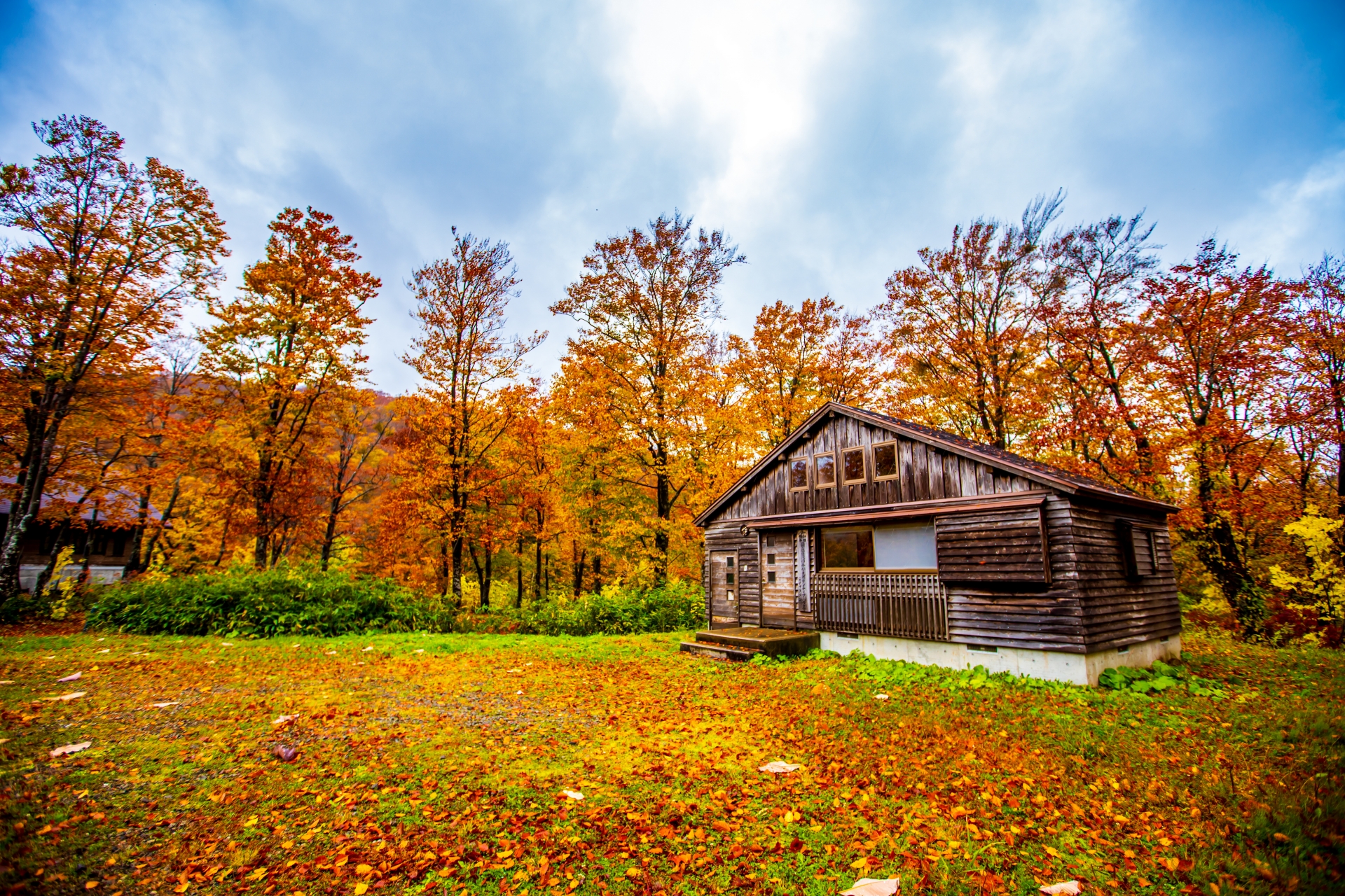 紅葉に囲まれた山あいの木造の建物