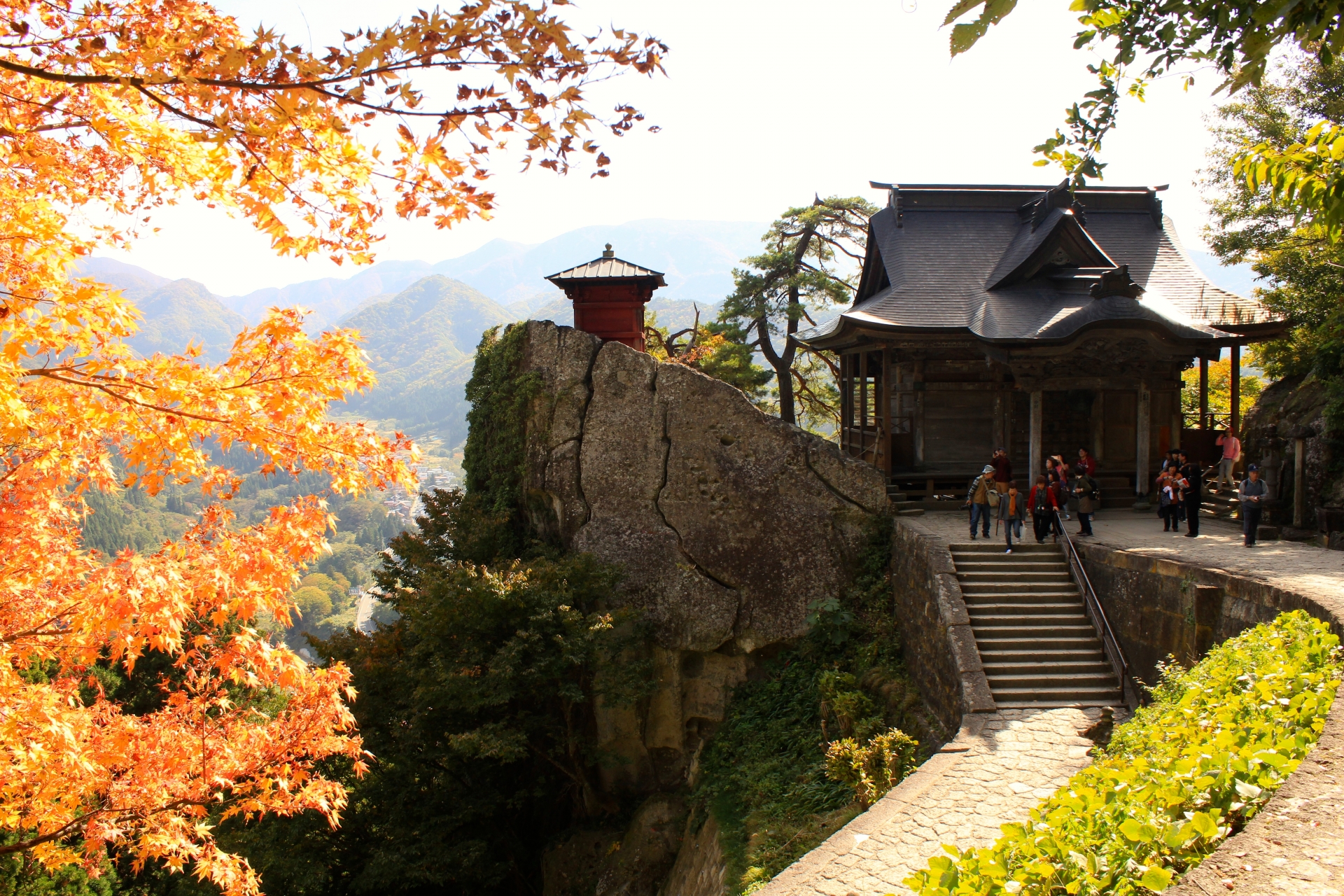 断崖の上に立つ納経堂と紅葉に染まる山寺の谷